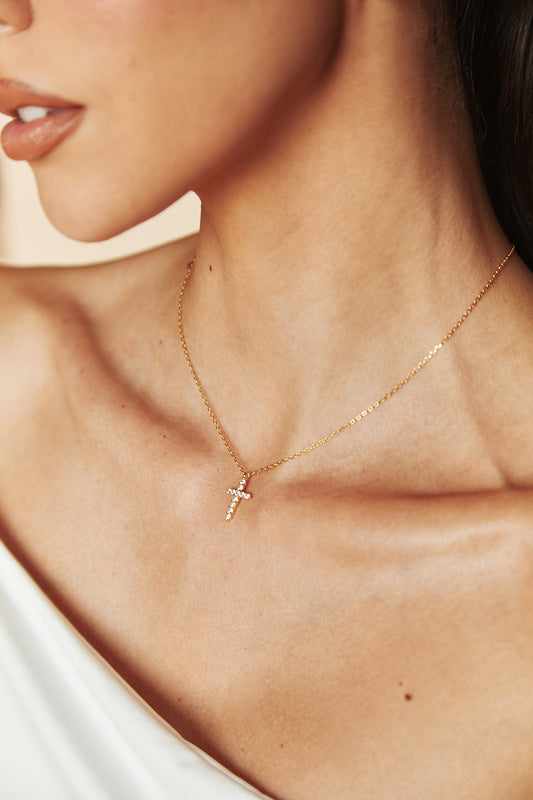 Model wearing 18k gold vermeil cross necklace with cubic zirconia